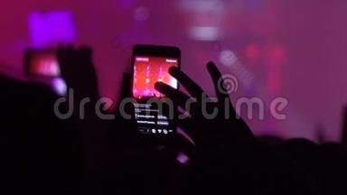音乐会上的人用手机拍摄视频。